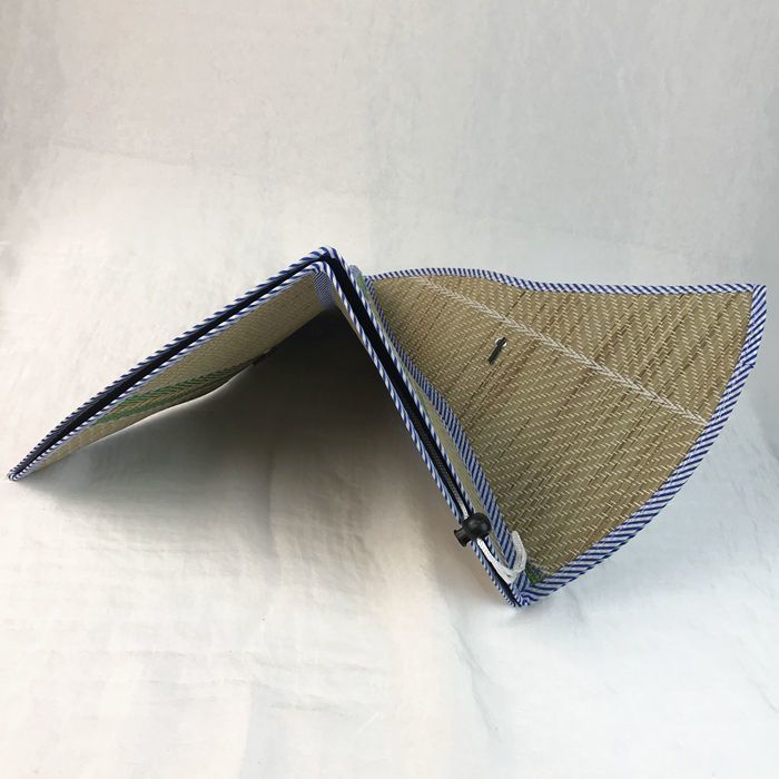 Foldable wide brim straw sun hat on display stand